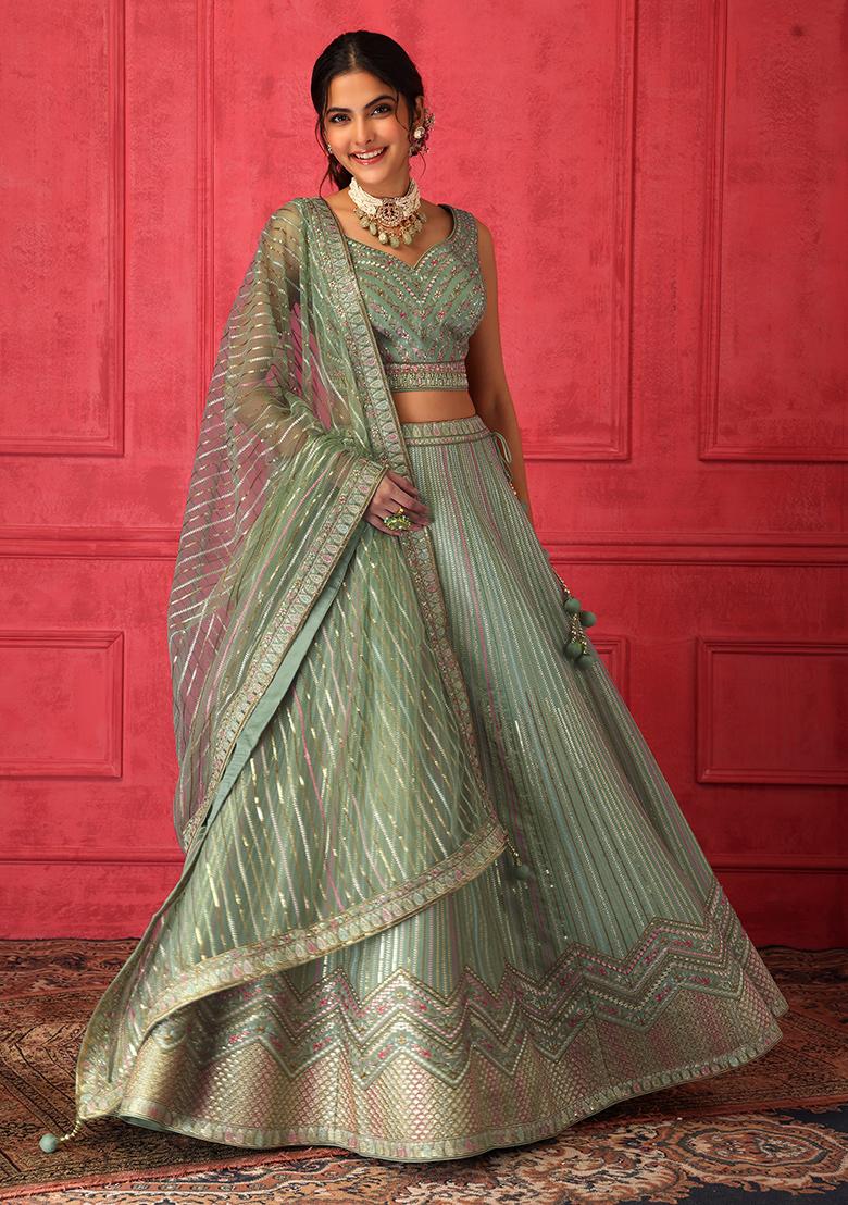 Photo of Embellished gold lehenga with contrasting green jewellery