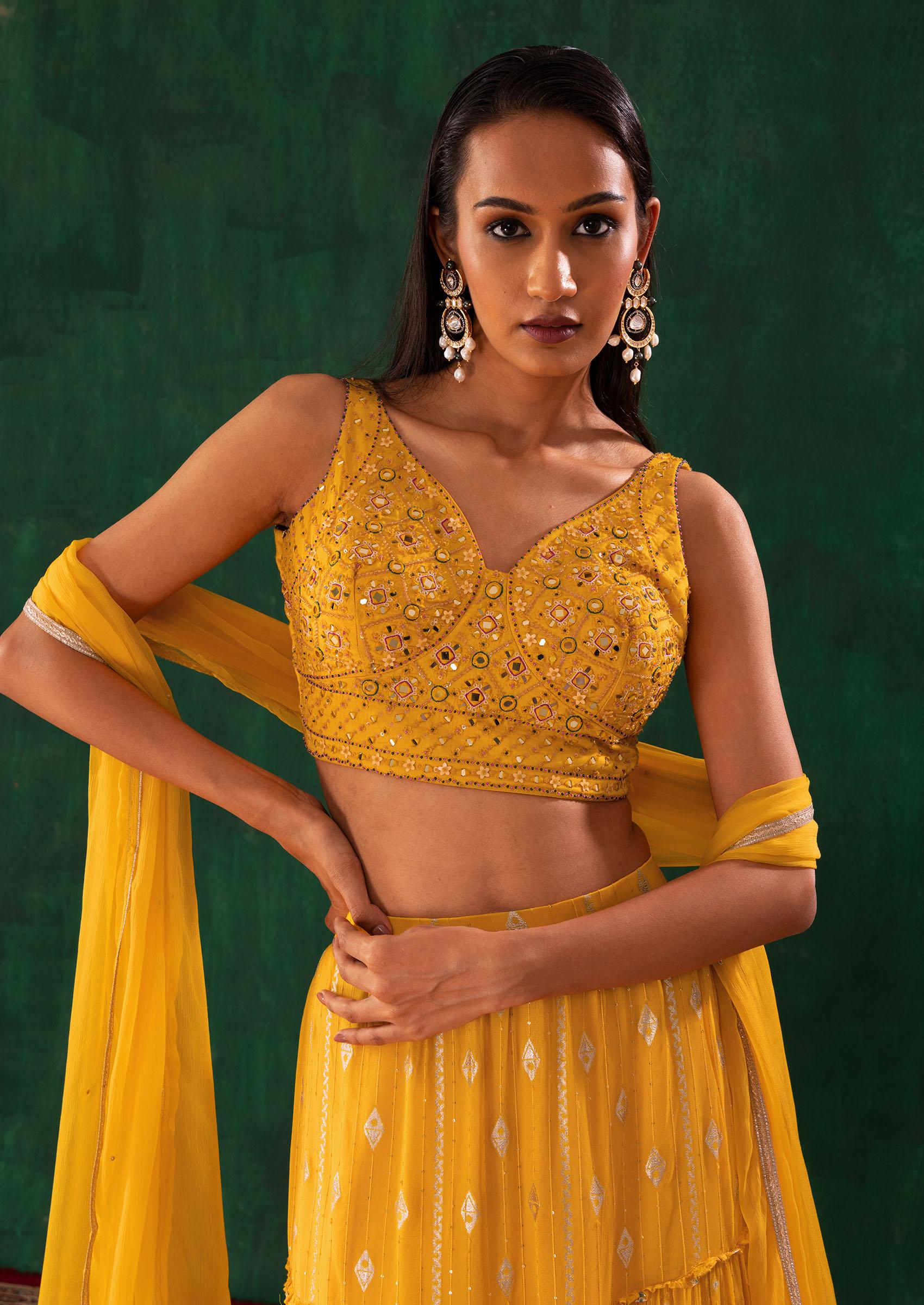 Yellow flowy lehenga with off-shoulder blouse by Izzumi Mehta