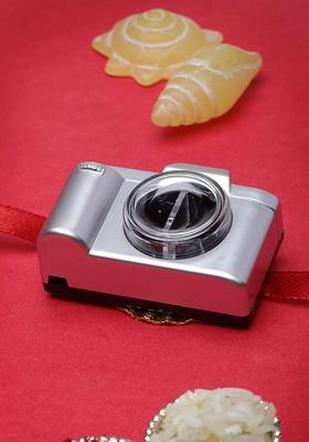 Boys Grey And Red Solid Camerashaped Rakhi With Roli Chawal