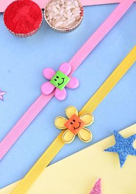 Pink Kids Set Of 2 Floral Smiley Thread Rakhis With Roli Rice And Greeting Card