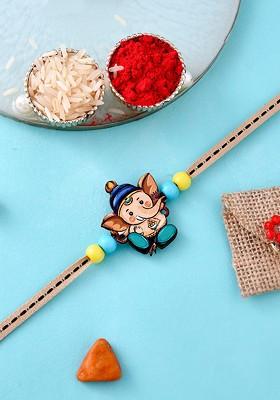 Blue Kids Ganesha Designed Thread Rakhi With Roli Chawal And Greeting Card