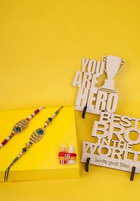 Set Of 2 Gold Plated Oval Shaped Rakhi With Gift Stand And Roli Chawal